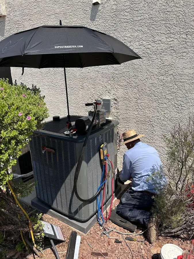 HVAC technician performing outdoor AC maintenance in Colonie